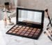 Make-up-Palette mit Pinseln und Serum auf Marmortisch
